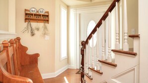 A wooden staircase with white balusters leading to a door with a decorative glass window.