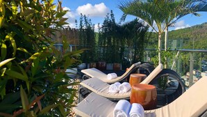 A rooftop lounge area with sun loungers, towels, and potted plants. - Ha Long New Century Hotel (Bai Chay)