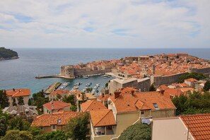 A coastal town with historic architecture, a marina, and a prominent fortification. - Hedera Estate, Hedera A32 (Dubrovnik)