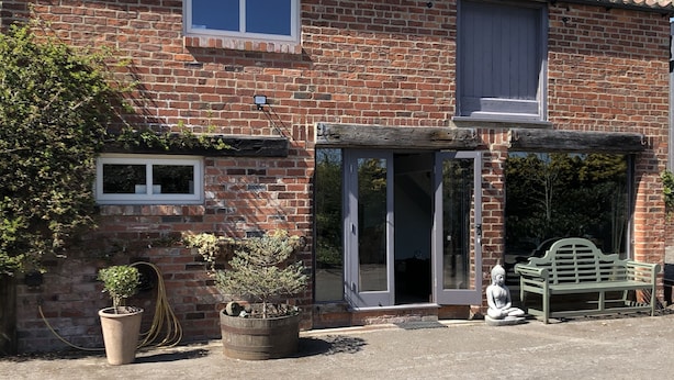 A brick house with a tiled roof, a front door, and a small porch with a bench. - Impeccable Cottage Suitable for 2 Adults & 1 Child (York)