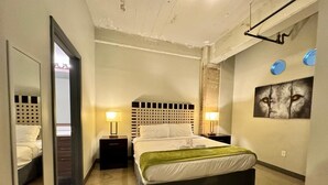 A hotel room with a bed, two bedside tables, a mirror, and a wall-mounted picture. - 2 BR | 2 Bath | Downtown | Free Valet Parking | 5 (Dallas)