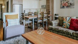 Una sala moderna con comedor, que incluye un sofá, sillas y una mesa de centro.