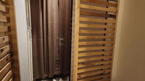 Une porte en bois dotée d’un système de glissement et d’un rideau.