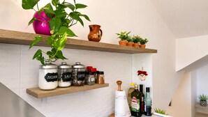 A kitchen with shelves holding jars labeled 'ZUCCHERO,' 'SALE,' and 'COFFEE,' a wooden rolling pin, and a bottle of extra virgin olive oil. - Raffaella Holiday Home, Agerola & Amalfi Coast (Agerola)
