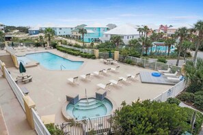 Un resort con piscina, sillas de descanso y jacuzzi.
