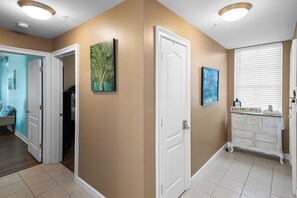A hallway with a beige wall, white doors, and a white cabinet with drawers.