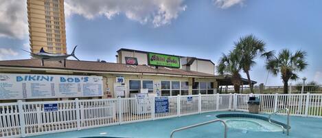 A swimming pool area with a sign for Bikini Bob's Bar & Grill.