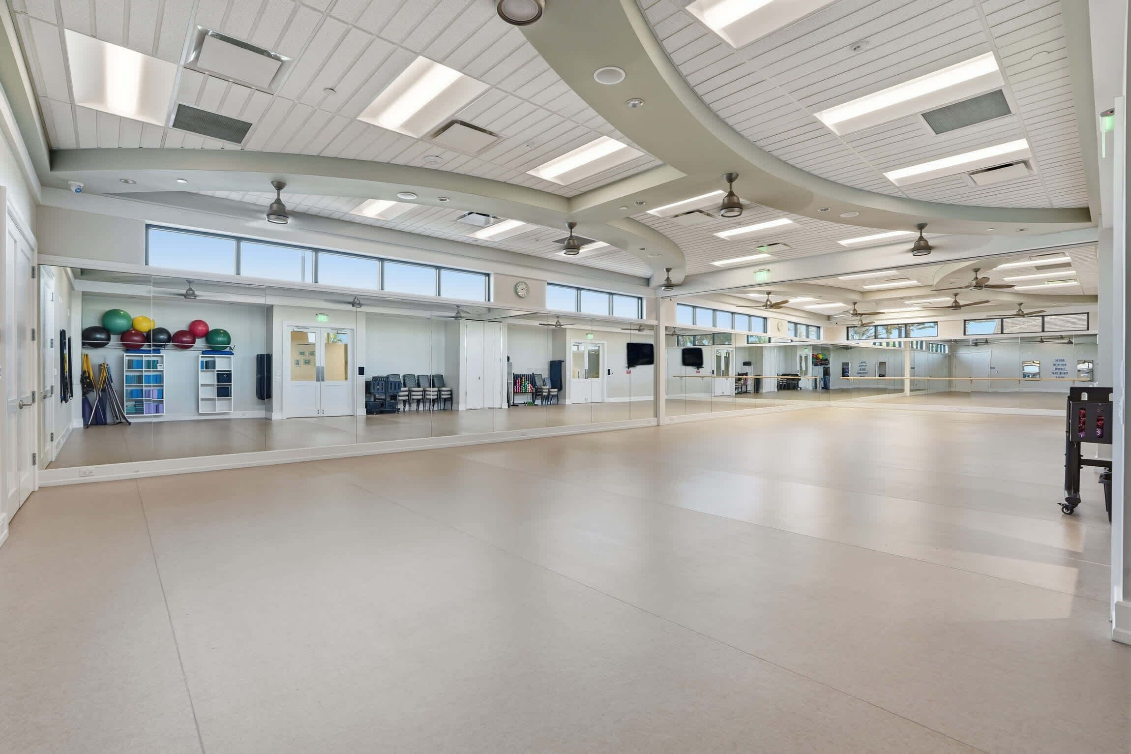 A spacious, well-lit indoor area with a high ceiling, large windows, and a clean, modern design.
