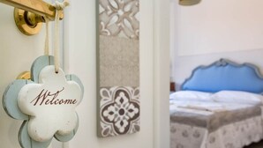 Una habitació amb un llit, un cartell de 'Welcome' i decoració mural.