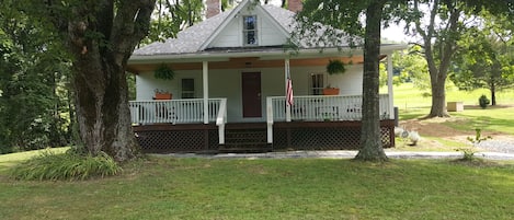 A house with a porch, a flag, and a small garden area.
