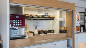 A self-service coffee station with a coffee machine, baskets of snacks, and a menu sign. - Kyriad ECO - Toulon Ouest La Seyne sur Mer (La Seyne-sur-Mer)