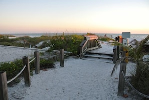 Walk along the boardwalk to the beach, where a small shelter marks the end of the path.