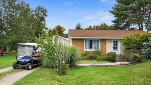 Una casa a un piano con facciata in mattoni e un piccolo giardino antistante.