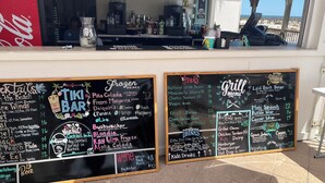 Een Tiki Bar met een krijtbord waarop drankjes en snacks staan vermeld.