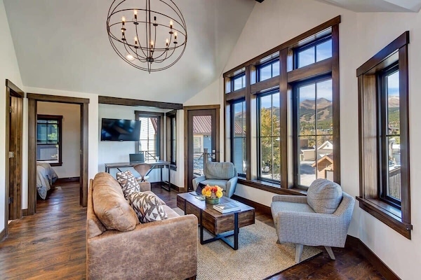Living room with mounted TV, desk, and access to private balcony