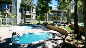 A residential area with two swimming pools, a brick pathway, and a multi-story building with balconies. - Spacious, upgraded Condo in Sierra Park Villas (Mammoth Lakes)