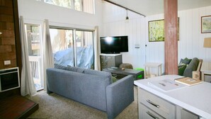 A compact living space with a grey sofa, a TV, a small table, and a white cabinet. - Spacious, upgraded Condo in Sierra Park Villas (Mammoth Lakes)