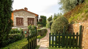 A stone building with a wooden gate and a stone pathway leading to it.