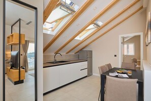 A modern kitchen with skylights, a dining area, and a view of the city.