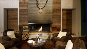 Una sala de estar acogedora con chimenea, sofás de cuero y una calavera de ciervo montada.