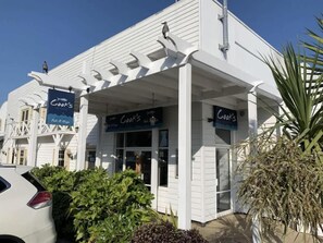A white building with a covered entrance and signs reading "Cook's."
