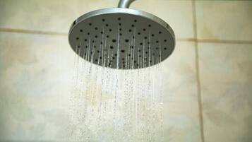 A showerhead with water flowing from it.