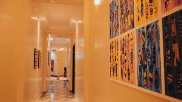 A hallway with a checkered floor and a wall adorned with colorful artwork.