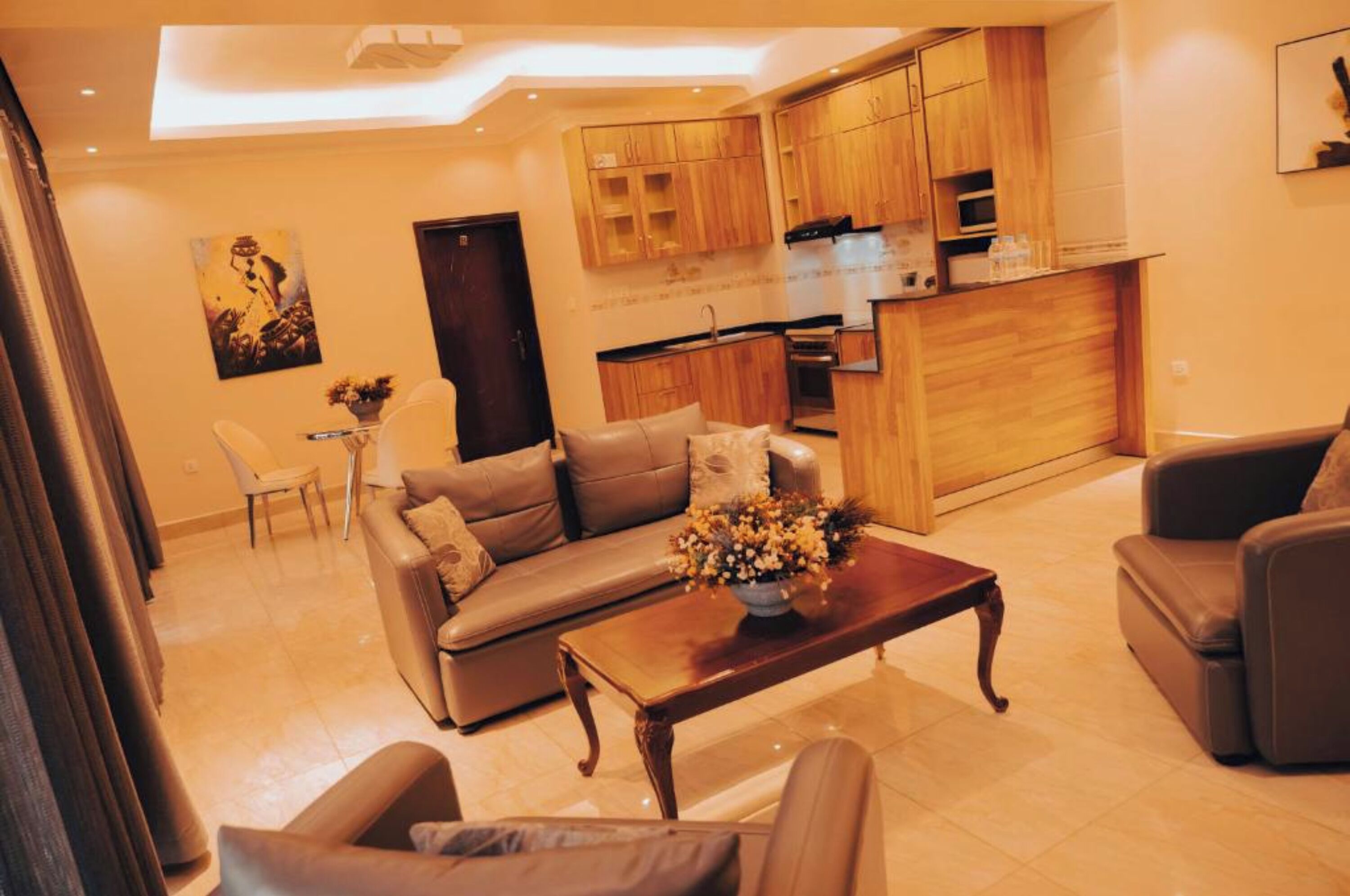 A modern living room with a sofa, coffee table, and a dining area with chairs.
