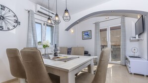 A modern dining area with a wooden table, beige chairs, and a clock on the wall. - Villa Spark **** with pool in Rogoznica / Zečevo (Rogoznoca)