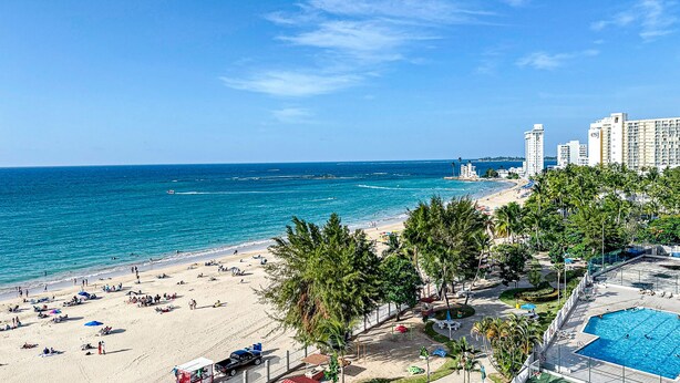 Un complexe hôtelier de bord de mer doté d’une piscine, d’une plage et offrant une vue sur l’océan.
