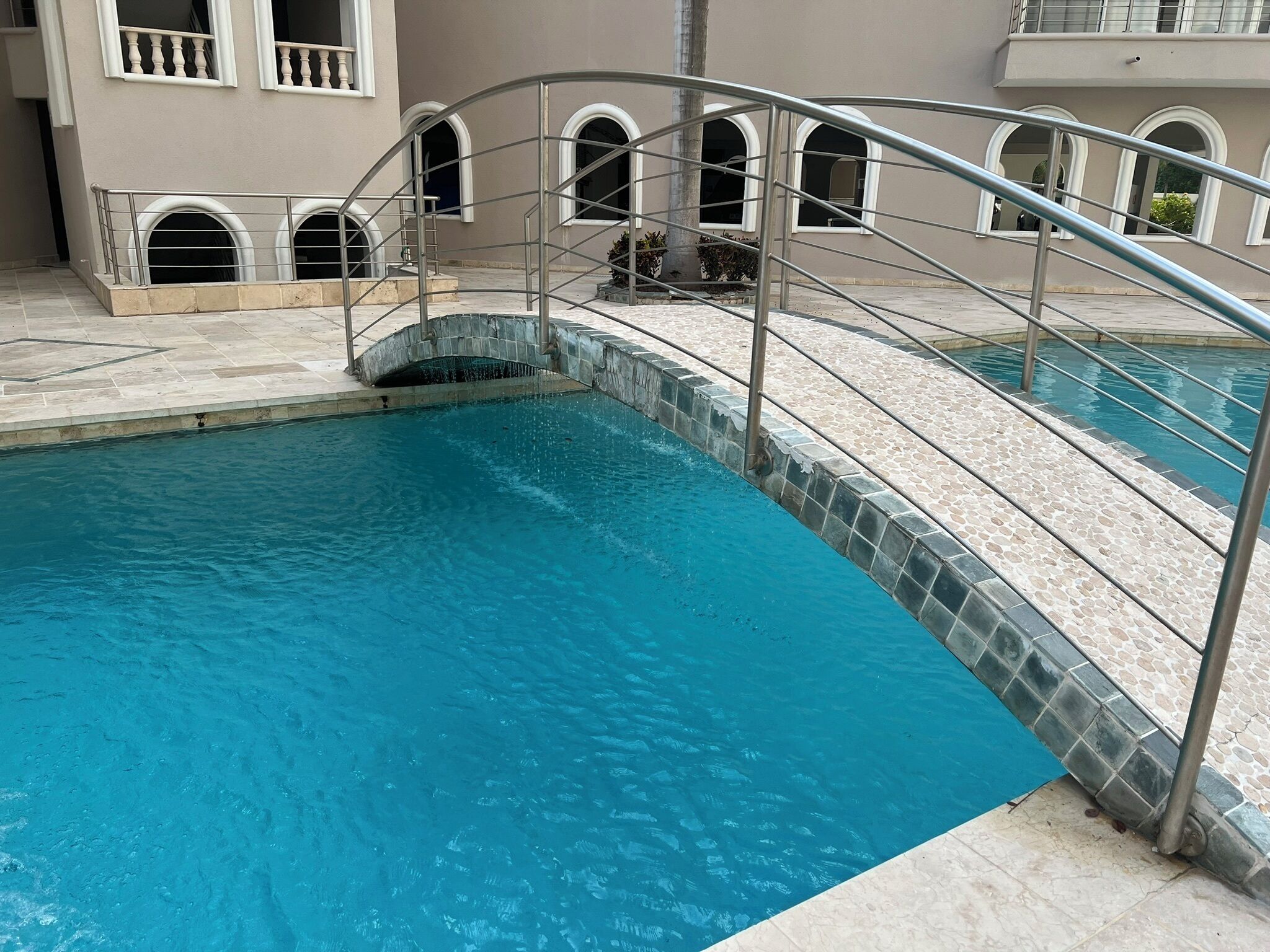 A swimming pool with a metal deck and a stone border.