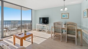 Amplio salón con un gran ventanal corredero que da a un balcón con vistas a la playa.