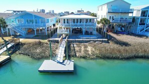 A waterfront property with a dock, a pool, and multiple buildings with balconies. - Barbee's Flamingo-4 Bedroom/2 Bath Channel House in Cherry Grove (North Myrtle Beach)