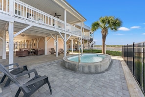 A covered outdoor area with a pool, lounge chairs, and a palm tree. - Barbee's Flamingo-4 Bedroom/2 Bath Channel House in Cherry Grove (North Myrtle Beach)