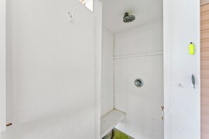 A bathroom with a shower, a toilet, and a sink.
