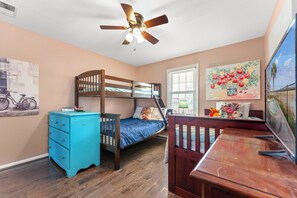 A bedroom with a bunk bed, a desk, a dresser, and a ceiling fan. - Barbee's Flamingo-4 Bedroom/2 Bath Channel House in Cherry Grove (North Myrtle Beach)