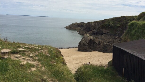 A coastal landscape with a sandy beach, rocky cliffs, and a distant island. - House 6 persons near Port de Doëlan / 2 stars tourism (Clohars-Carnoët)