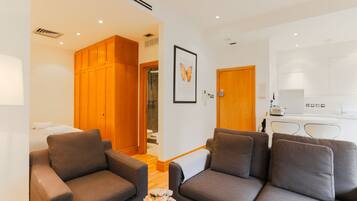 A modern living room with two sofas, a coffee table with flowers, and a wooden wardrobe.