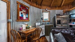 Una cocina rústica con muebles de madera, un refrigerador y una estufa.