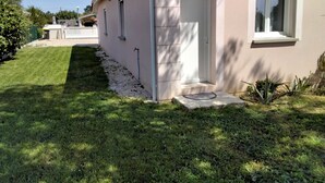 Une maison avec une pelouse bien entretenue, une porte blanche et une fenêtre.