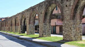 Una hilera de arcos de piedra con una calle pavimentada al frente.