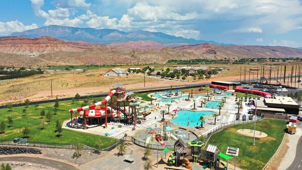 Enjoy a fun-filled day at the resort's outdoor recreational area, featuring a water slide, multiple pools, and a lush lawn.