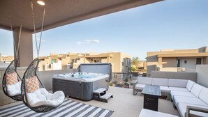 A rooftop terrace with a hot tub, hanging chairs, and a sofa. - Rooftop Hot Tub & Heated Pool (Washington)