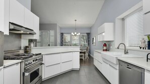 A modern kitchen with white cabinetry, a built-in stove, and a dishwasher. - Water Well Wonder|Near Apple & Domain|Pet Friendly (Austin)