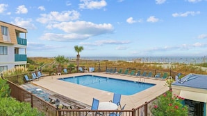 A pool area with lounge chairs and a view of the beach. - Uncrowded Beachfront Getaway with an Ocean View (Murrells Inlet)