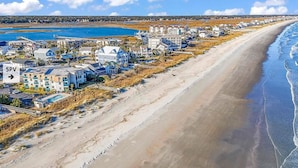 A coastal residential area with beachfront properties, a sandy beach, and a clear view of the ocean. - Uncrowded Beachfront Getaway with an Ocean View (Murrells Inlet)
