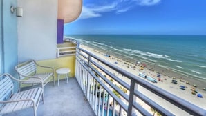 Un balcon avec vue sur une plage et l’océan.