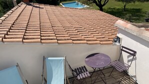 A rooftop terrace with a tiled roof, a pool, and outdoor furniture including a table and chairs. - Studio Avec Piscine (Saint veran/Orgon)