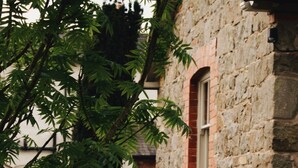 Un bâtiment en pierre avec un chemin de gravier menant à une fenêtre.
