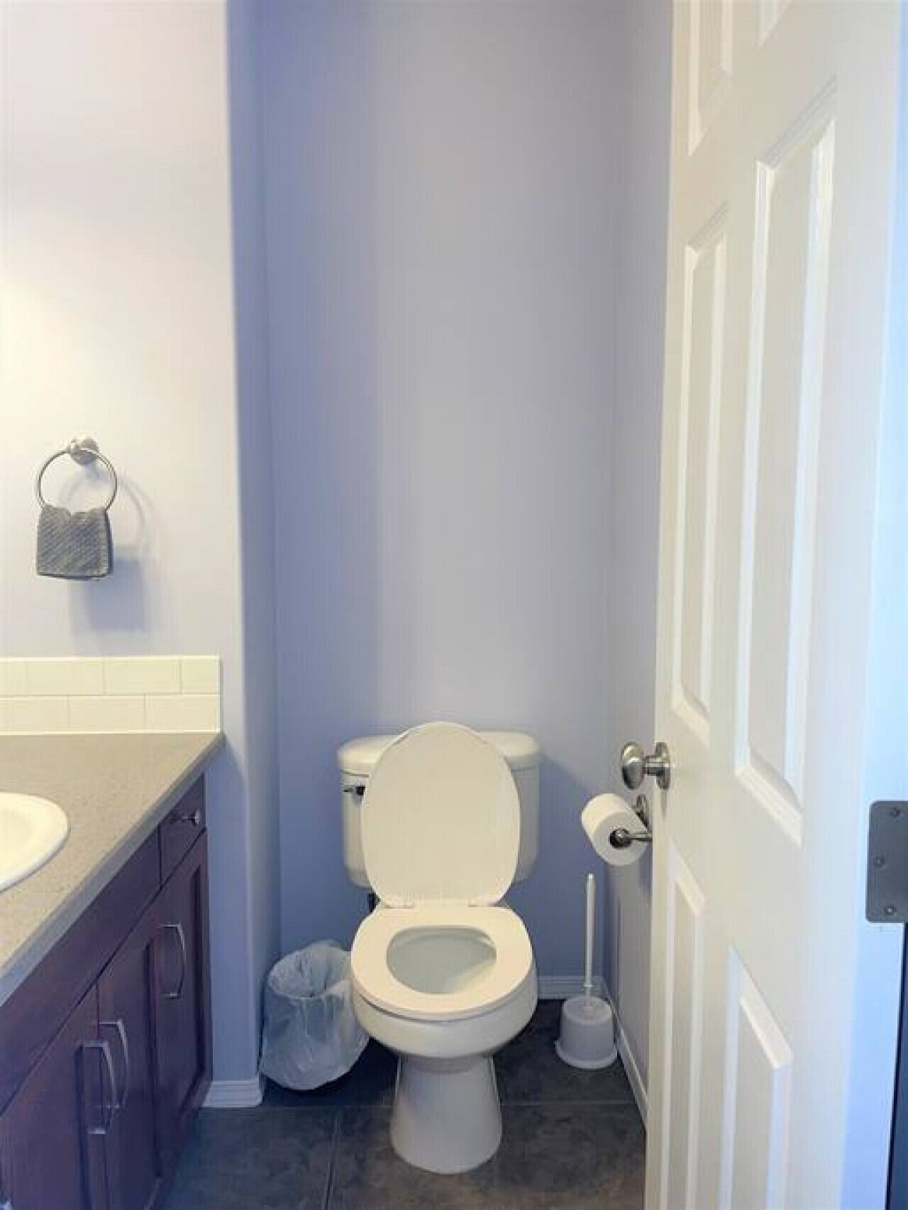 Un baño con inodoro, lavamanos y armarios.